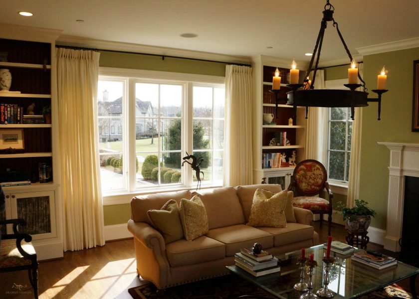 lined white panels on 1" metal rods in family room.